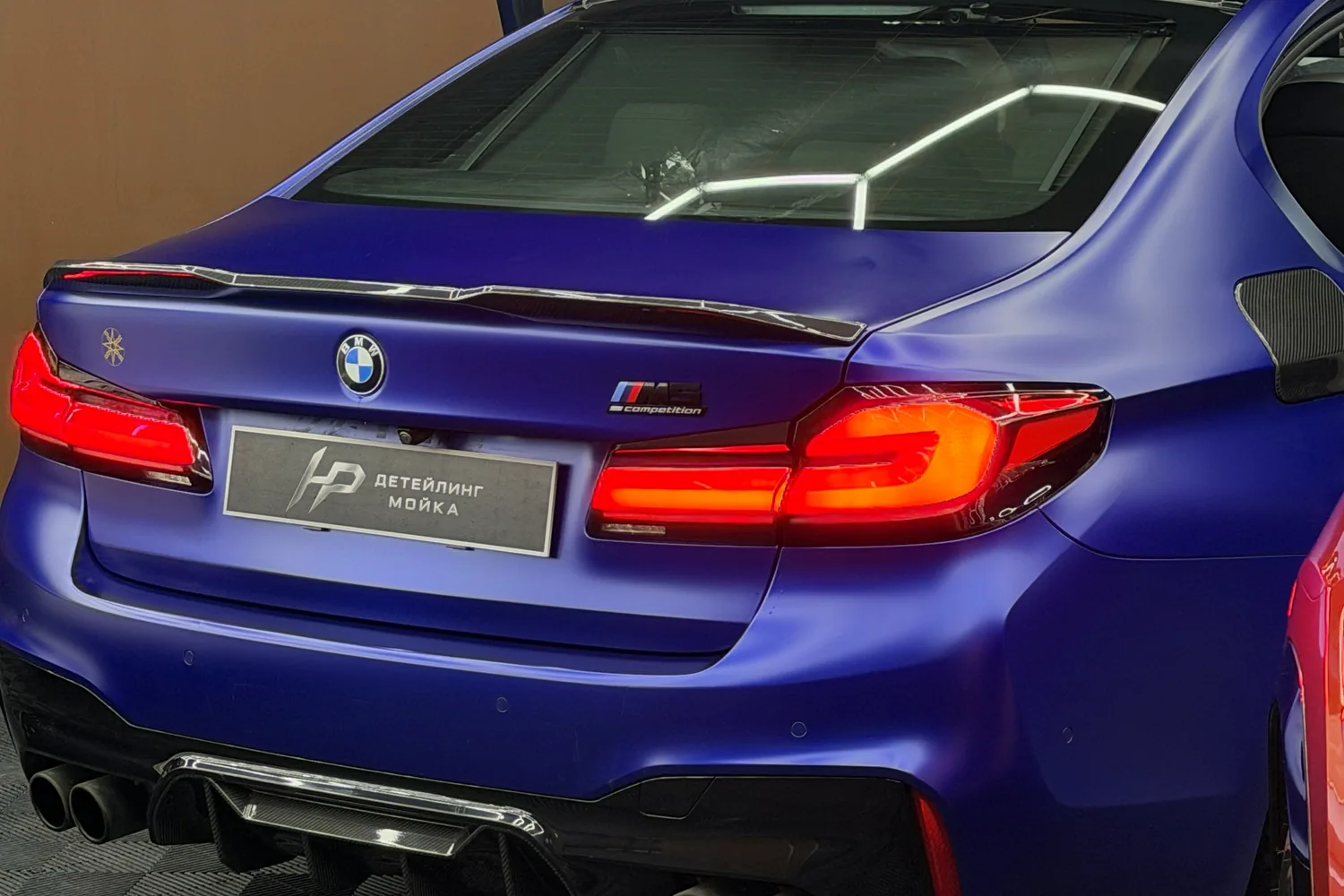 Задняя часть синего BMW с табличкой HP Detailing