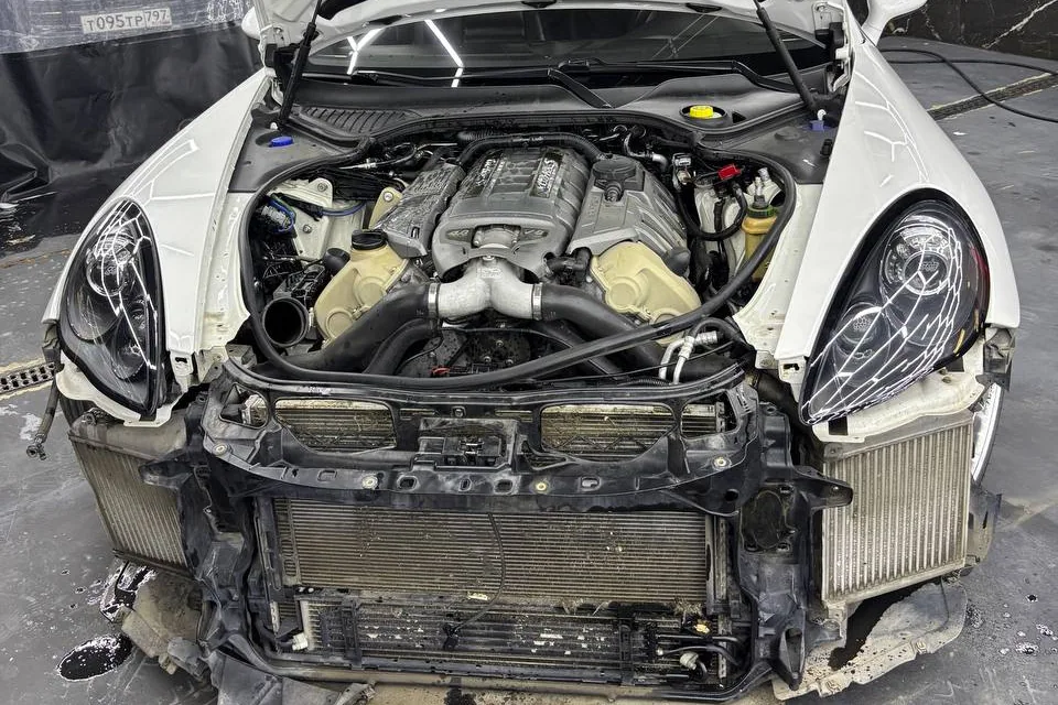 Загрязнения под капотом и на передней части Porsche со снятым бампером
