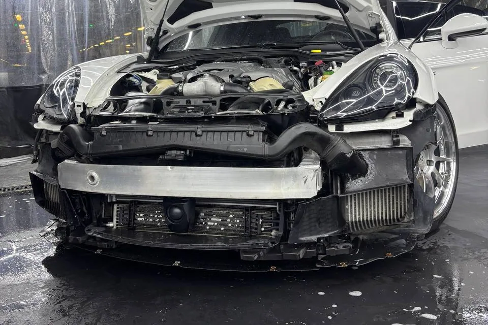 Передняя часть Porsche со снятым бампером после очистки